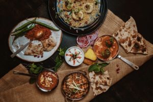 Table laid out with different food dishes presented artistically on hessian material